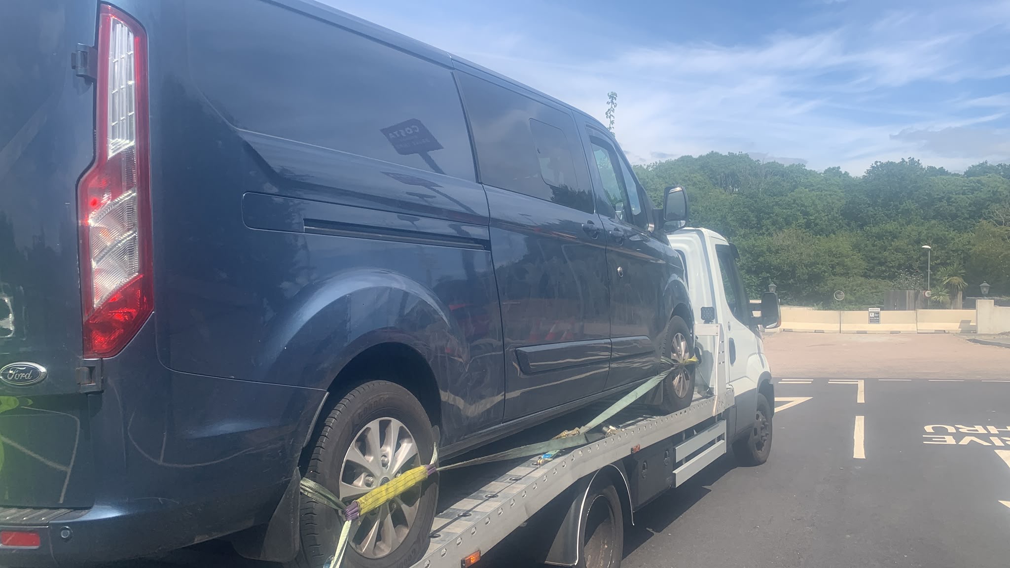 Commercial Ford van secured on a recovery truck