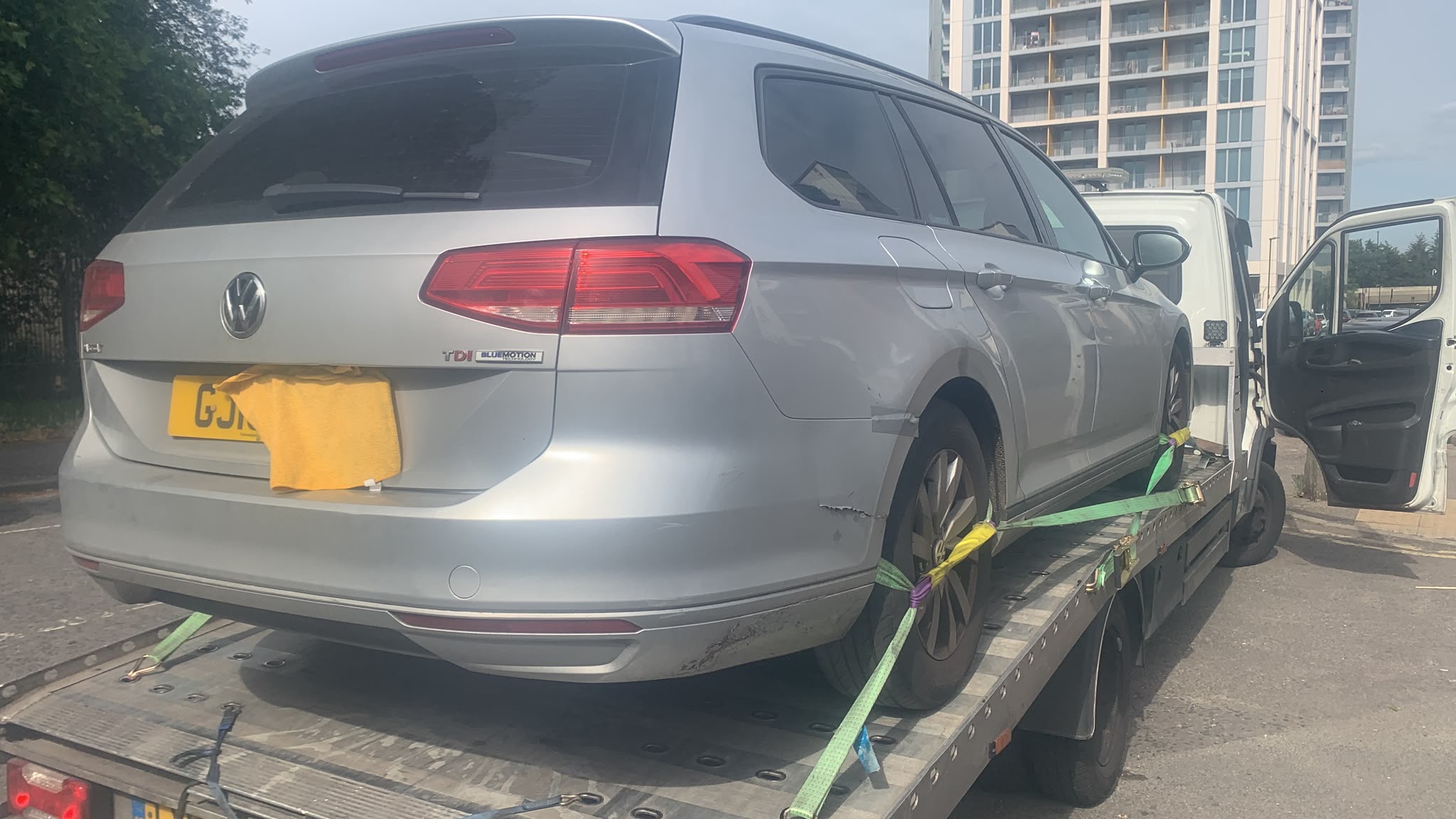 Silver estate car safely strapped to a recovery truck